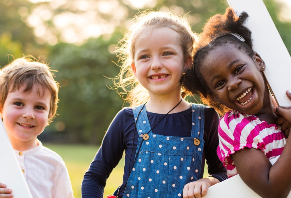 Three kids smiling. DPD smiles in St. Charles and Wheaton Dental crowns in Wheaton and St. Charles